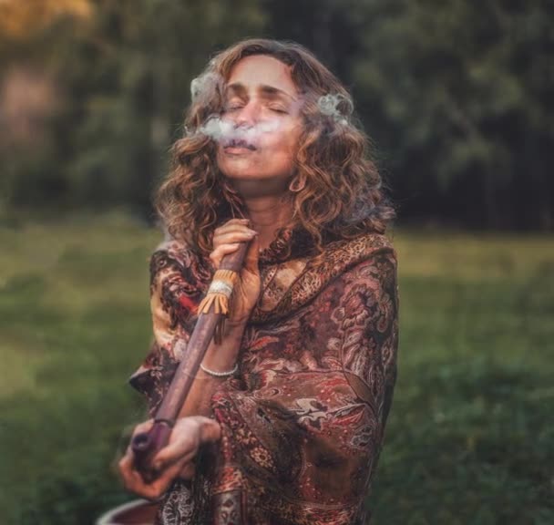 Krásná šamanská žena a indiánská dýmka v přírodě. Fotografie pohybu. — Stock video