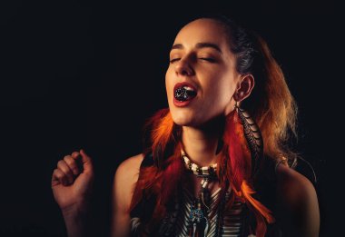 Güzel bir kadının siyah arka planda böğürtlen yediği yakın plan..