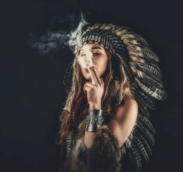 Belle fille chamanique en studio sur fond noir avec cigarette à la main. — Photo