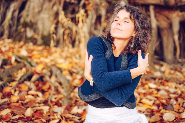 Mulher na pilha de folhas de outono. — Fotografia de Stock