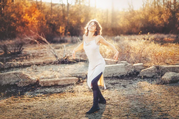 Piękna kobieta tańcząca w naturze o zachodzie słońca. — Zdjęcie stockowe