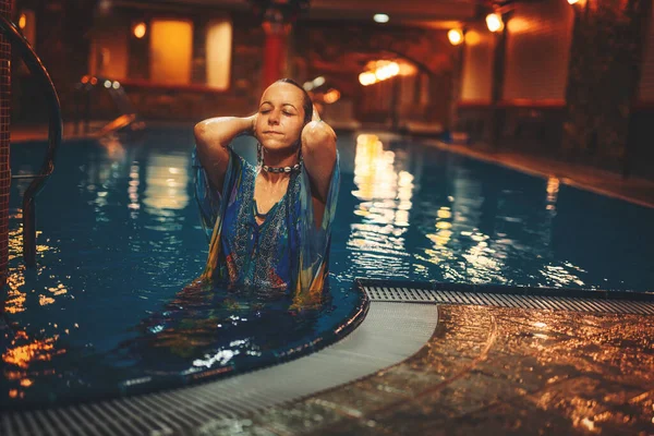 Hübsche junge Frau entspannt sich im Pool. — Stockfoto