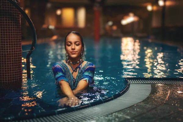 Pretty young woman relaxing in the pool. — Stock Photo, Image