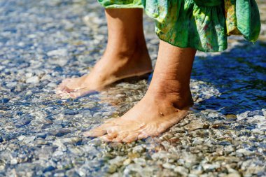 Kadın ayakları üzerinde deniz kıyısı.