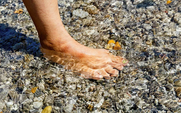 Női láb a tengerparton. — Stock Fotó