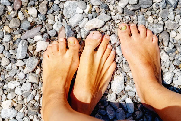 Férfi és női lábak a tengerparton. Kilátás felülről. — Stock Fotó
