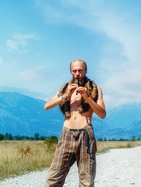 Man with a flute standing on the road — Stock Photo, Image