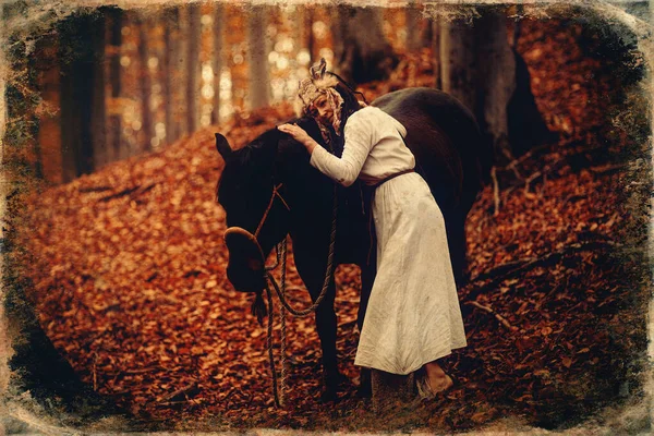 Femme chamane dans le paysage d'automne avec son cheval. Ancien effet photo. — Photo