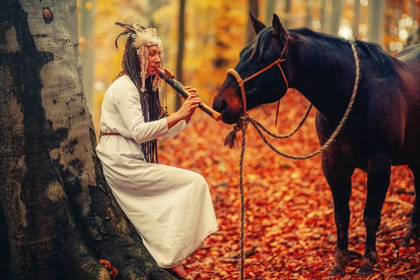 Shaman woman in autumn landscape with her horse. — Stock Photo, Image