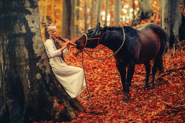 Shaman woman in autumn landscape with her horse. — Stock Photo, Image
