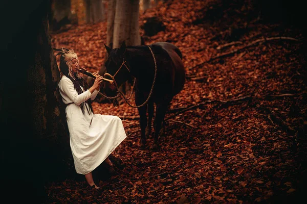 Shaman woman in autumn landscape with her horse. — Fotografia de Stock