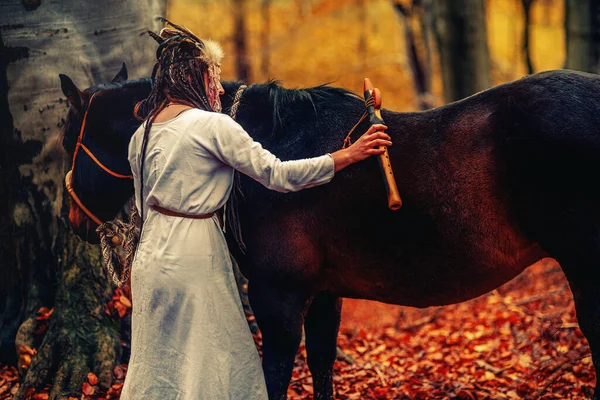 Shaman woman in autumn landscape with her horse. — Fotografia de Stock
