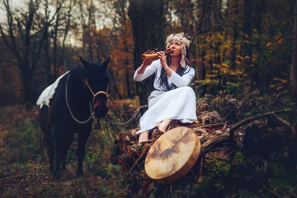Shaman woman in autumn landscape with her horse. — стоковое фото