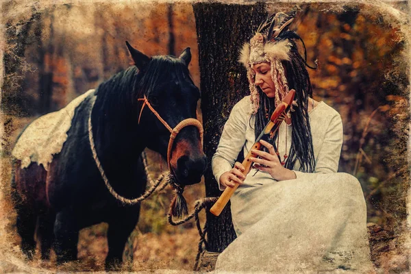 Šaman žena v podzimní krajině se svým koněm. Starý efekt fotografie. — Stock fotografie