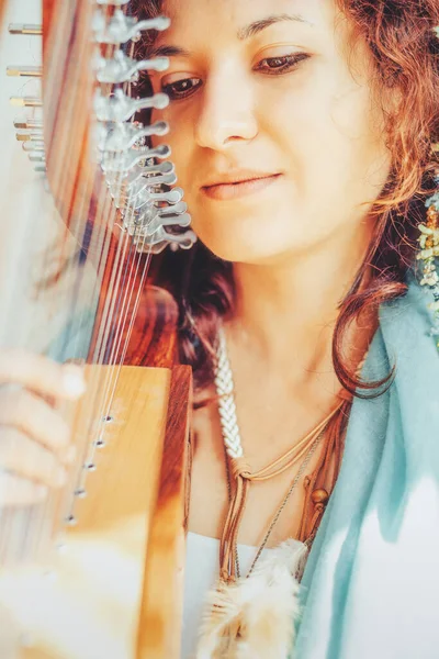 Woman with a harp. Beautiful girl harpist playing her instrument. — Stock Photo, Image