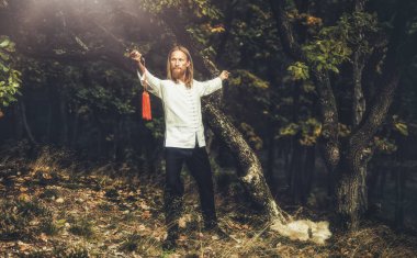 Orta yaşlı beyaz bir adam yazın tai chi yapıyor. Meditasyon ve doğada rahatlama. Sağlıklı yaşam tarzı ve spor.