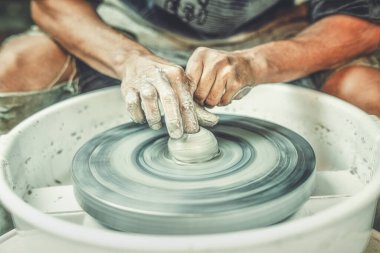 Potter çarkı ve çömlekçi elleri, çömlekçinin becerikli elleri balçığı şekillendiriyor..