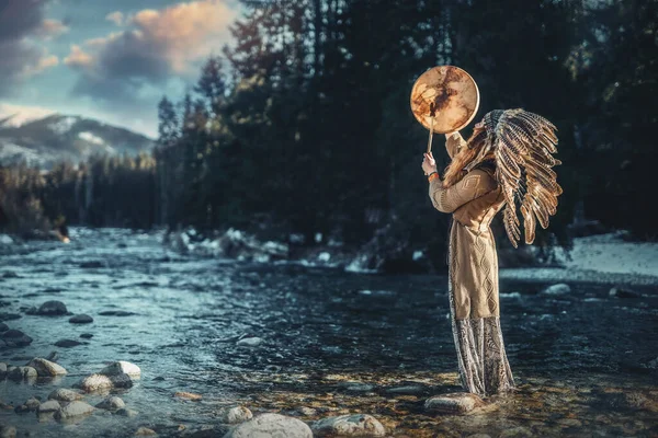 Mooi sjamanistisch meisje spelen op sjamaan frame drum in de natuur. — Stockfoto