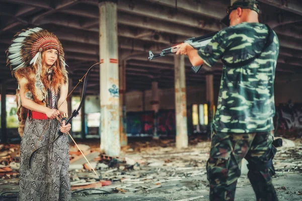 Airsoft soldier and indian woman in the old industry building. — Fotografia de Stock