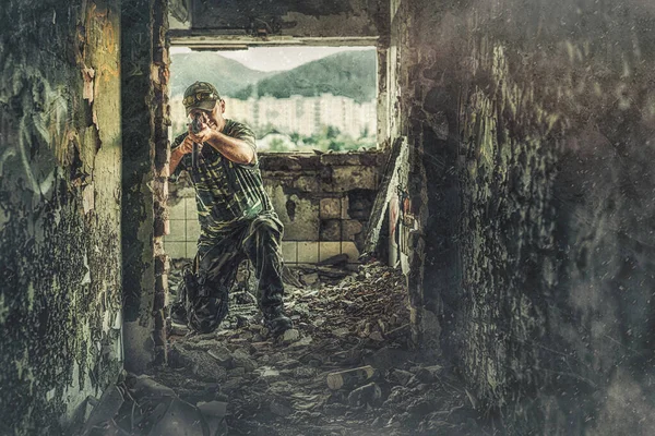 Airsoft sgrungeier in the grunge industry building. Old photo effect. — Photo