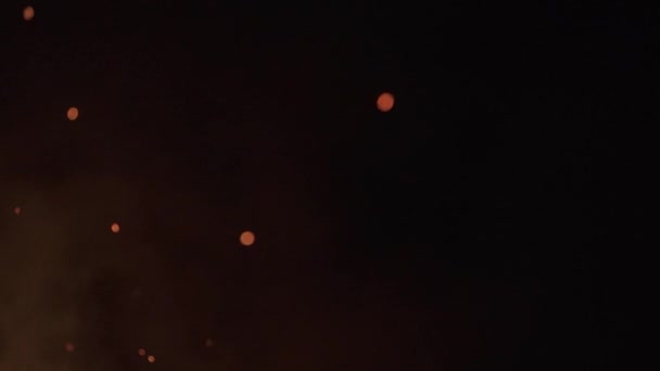 Orange glödande flygande glöd brinner på svart bakgrund. Långsamma rörelser. — Stockvideo