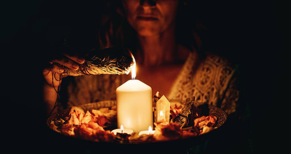 incense in a woman hand, incense smoke on a black background