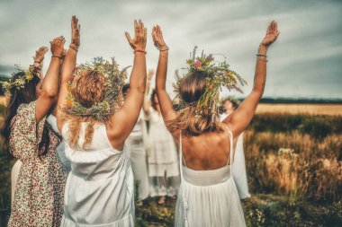 Women in flower wreath on sunny meadow, Floral crown, symbol of summer solstice