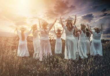 Women in flower wreath on sunny meadow, Floral crown, symbol of summer solstice