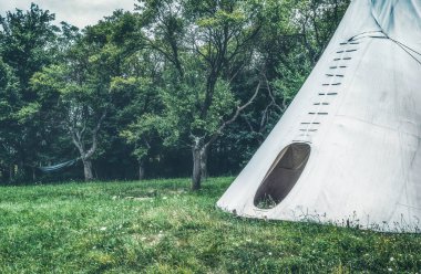 white teepee indian tent standing in beautiful landscape