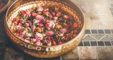 Rose flower in a brass bowl. Spa and aromatherapy