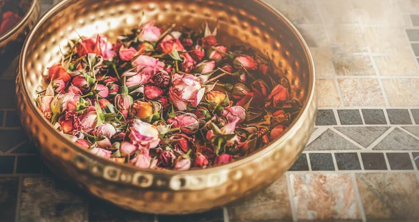 Rose flower in a brass bowl. Spa and aromatherapy