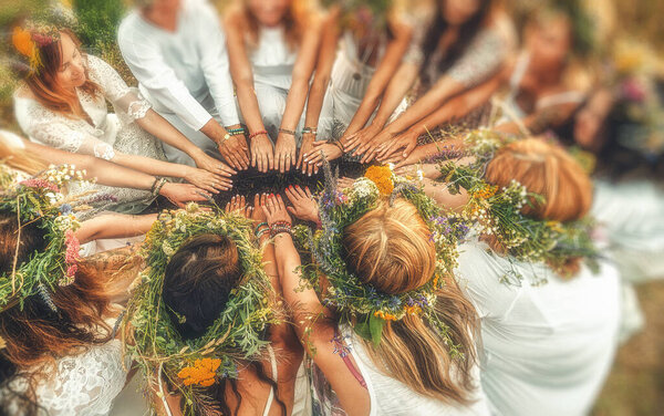 Women in flower wreath on sunny meadow, Floral crown, symbol of summer solstice