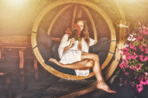 Beautiful Woman Sits Wooden Swing Bouquet Red Roses Her Hand — Stock Photo, Image