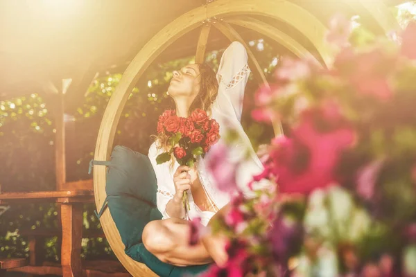 Beautiful Woman Sits Wooden Swing Bouquet Red Roses Her Hand — Stock Photo, Image