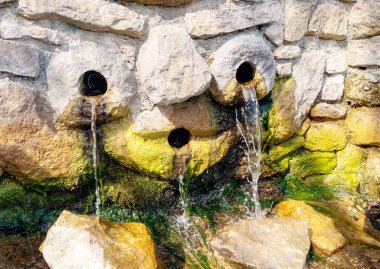 Şelale yosunlu kayaların üzerine düşüyor