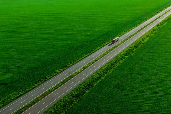 Vrachtwagen Rijden Asfaltweg Langs Groene Velden Bij Zonsondergang Gezien Vanuit — Stockfoto