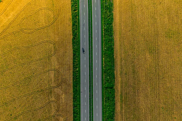 Zwarte Auto Rijden Asfaltweg Langs Gele Velden Van Tarwe Bij — Stockfoto