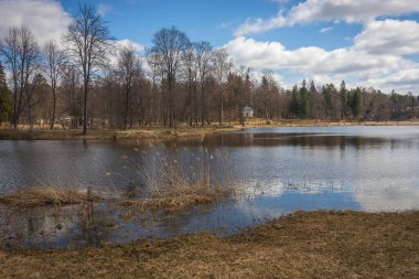 Upper reaches of Moscow river in late autumn with bare trees and reflections in water in Russia