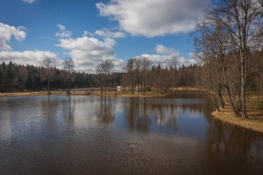 Upper reaches of Moscow river in late autumn with bare trees and reflections in water in Russia