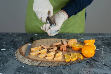 Eldivenli bir erkek mermer masadaki karidese tuz ekliyor. Yüksek kalite fotoğraf