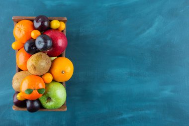 Mermer arka planda çeşitli taze meyve çeşitleriyle ahşap eski kutu 