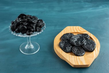 Mavi arka planda lezzetli kurutulmuş erik tabakları 