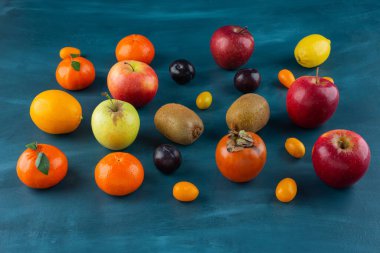 Koyu mavi arka planda çeşitli taze meyve çeşitleri var. Yüksek kalite fotoğraf