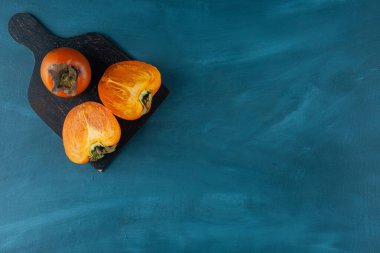 Koyu ahşap bir tahtaya yerleştirilmiş tam ve dilimlenmiş hurma meyvesi. Yüksek kalite fotoğraf