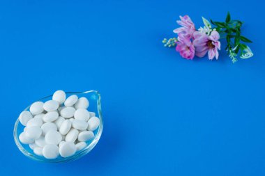 Yuvarlak diş etleri ve mavi üzerine yerleştirilmiş çiçekli cam tabaklar.