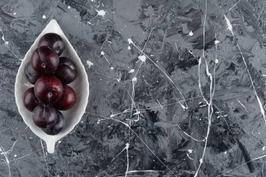 Yaprak şeklinde taze erik meyveleri mermer bir zemine yerleştirilmiş. Yüksek kalite fotoğraf