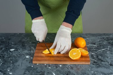 Erkek eller mermer masada taze limon kesiyor.