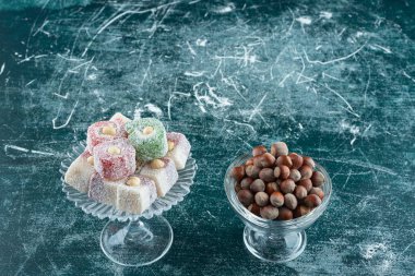 Organik fındık kaseleri ve mermer yüzeyde tatlı tatlar 