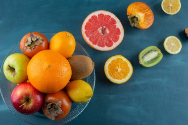 Çeşitli taze sulu ve dilimlenmiş meyvelerle dolu cam bir tabak. Yüksek kalite fotoğraf