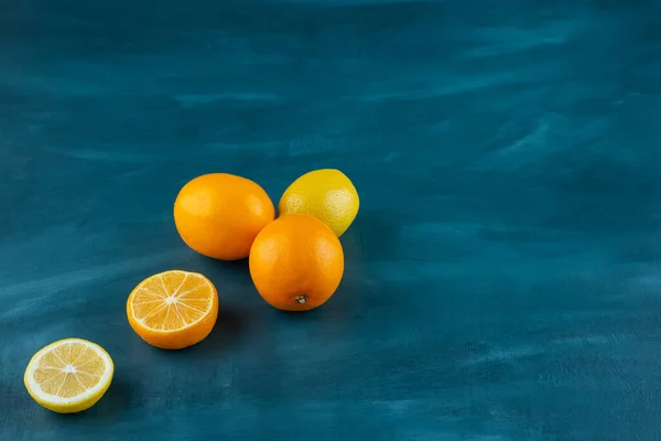 Tam ve dilimlenmiş limonlar mermer zemine yerleştirilmiş.. 